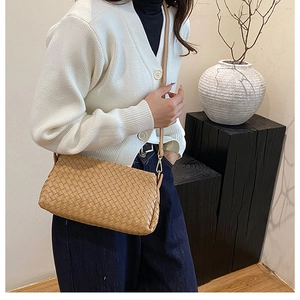Gros plan du sac bandoulière tressé caramel sur modèle pour le style et la taille