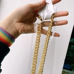 Detail of gold hip hop cuban link chain with sparkling rhinestones in packaging