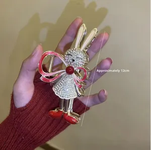 Detail view of 12cm gold rabbit hair claw clip with rhinestones and tassel decoration