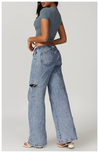 Detail of light blue high-waisted distressed wide-leg jeans with slim fit t-shirt