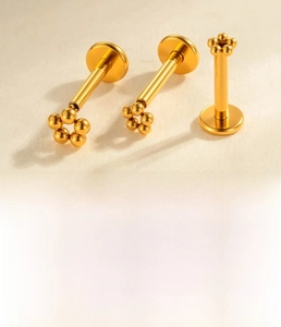 Macro view of titanium labret stud with golden five-bead flower top and 1.2mm x 8mm post