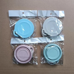 Detailed view of four portable folding silicone bowls with carabiners in different colors