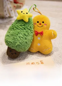 Close-up of plush green Christmas tree with yellow star and gingerbread man on white rug