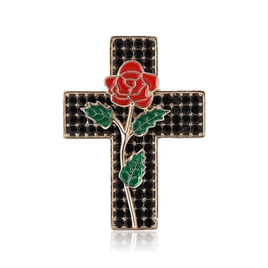 Vintage gold cross brooch with red rose and black rhinestones on white background