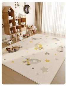Detail of soft beige kids rug with rocket and star patterns on wooden floor
