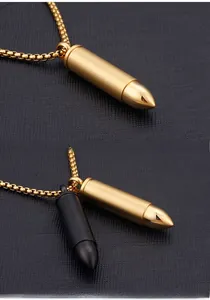 Detail of bullet-shaped steel pendant necklaces in gold and black with box chain