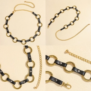 Detail view of black leather waist chain with gold carved rings and metal extension