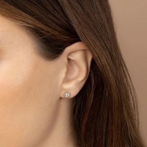 Macro detail of a classic round halo stud earring featuring micro-pave cubic zirconia crystals