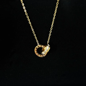 Detailed view of gold titanium necklace with Roman numerals and crystal double rings