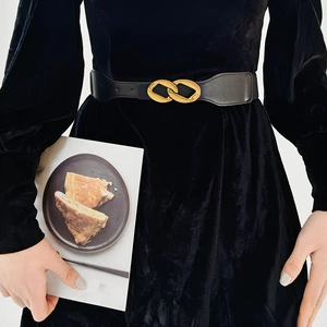Fashionable black elastic waist belt with a golden double ring buckle on a velvet dress