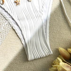 Detail of white bikini bottoms with ribbed texture, seashell and starfish charms