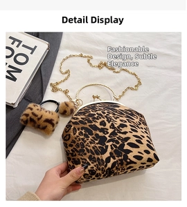 Detail of leopard print handbag with gold circular handles and plush pompom accessory