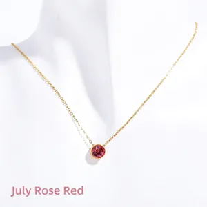 Close-up of July birthstone necklace with rose red zircon and golden chain on a bust