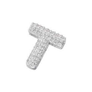 Macro view of silver letter T pendant fully paved with sparkling cubic zirconia crystals