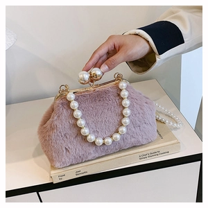 Close-up of pink faux fur shell bag with elegant pearl handle and large pearl clasp detail