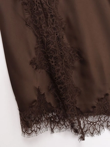 Close-up of silky dark brown satin fabric featuring intricate eyelash lace trim detailing