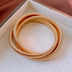 Détail du bracelet triple enveloppant doré flexible style tubogas dans son coffret bijou