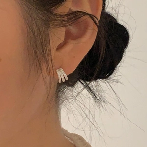 Close-up of minimalist 925 silver stud earrings with zircon inlay on model's ear