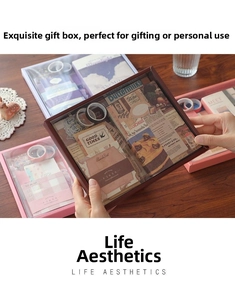 Detail shot of vintage stationery gift set including paper, stickers, and tapes on wood
