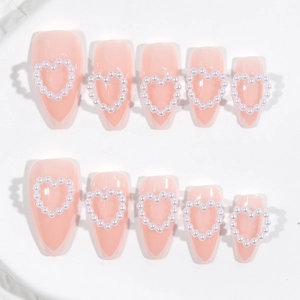 Pink almond press-on nails with white pearl heart designs set of 10 pieces on white background