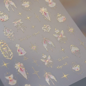 Golden foil nail art decals featuring crown and butterfly patterns with a gradient finish