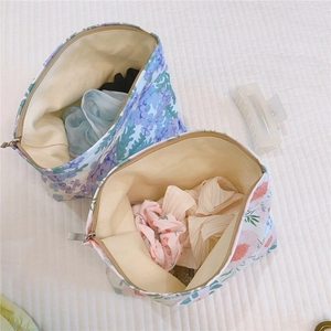 Detail of floral cotton makeup bags set showing interior capacity and golden zippers