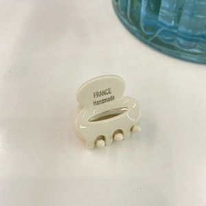 Detail of a mini ivory acetate hair claw clip with France Handmade lettering on top