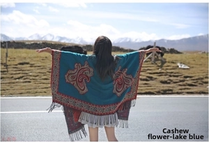 Detailed view of bohemian blue paisley cashmere shawl with fringe against mountain scenery