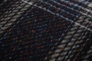 Macro view of gradient knitted scarf fabric with colorful speckled herringbone texture