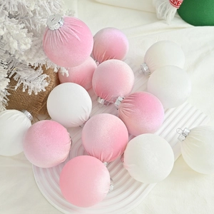 Pink and white flocked velvet Christmas ball ornaments set on a rustic tray for holiday decor