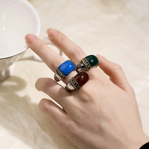 Fashionable titanium steel ring with inset cat eye stones on a model hand with white cup