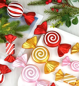 Flat lay of colorful electroplated candy Christmas ornaments with swirls on pine branches