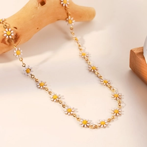 Detalle del collar de cadena de oro 18K con pétalos de margarita blancos y centro amarillo