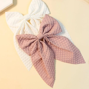 Detail showing white and pink waffle fabric hair bows with long ribbon tails