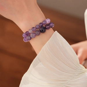 Makro-Detail von zwei Amethyst-Perlenarmbändern mit natürlicher Textur am Handgelenk