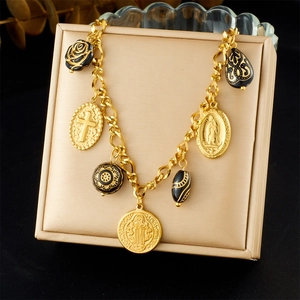 Close-up of black rose and cross charms on a gold-tone luxury vintage bracelet