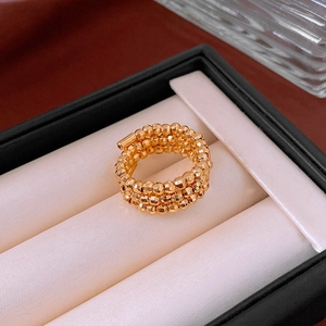 Detailed view of a layered golden beaded spiral ring displayed in a jewelry box