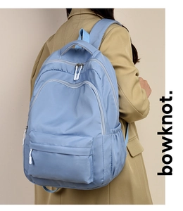 Detail view of light blue waterproof backpack with multiple zippers and stitching