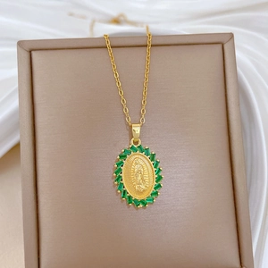 Detail of gold necklace with oval Virgin Mary pendant and green zircon gemstones