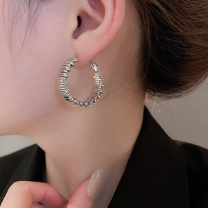 Nahaufnahme eleganter silberner Lagenohrringe am Model im unregelmäßigen Design