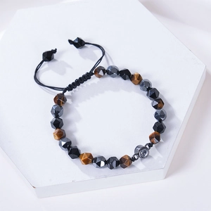 Vue détaillée du bracelet en œil de tigre et hématite sur socle hexagonal blanc