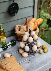 Détail d'un porte-œufs vintage à deux étages en fonte avec poignée coq dans un jardin