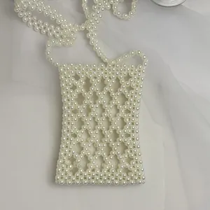Detail shot of white handmade pearl beaded crossbody phone bag with hollow grid texture