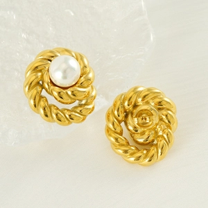 Detail of vintage gold-plated twist earrings featuring large round white pearls and studs