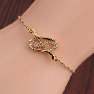 Detail of adjustable gold infinity bracelet with white zircon stones on model wrist