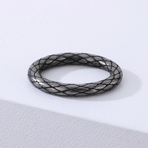 Close-up of a punk style stainless steel ring with snakeskin texture on white surface