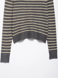 Detailed macro view of the striped knit sweater featuring ribbed cuffs and thick texture