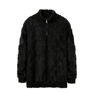 Détail d'un pull en polaire noir à quart de zip avec motif texturé à damier