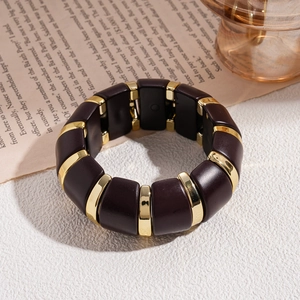 Détail d'un bracelet vintage en acrylique avec blocs de résine ambre et séparateurs dorés