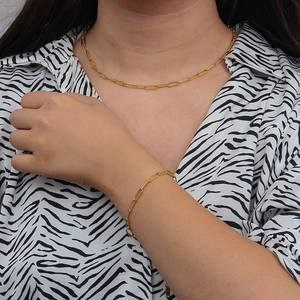 Detailed view of a gold twist chain necklace and bracelet set on a zebra pattern outfit